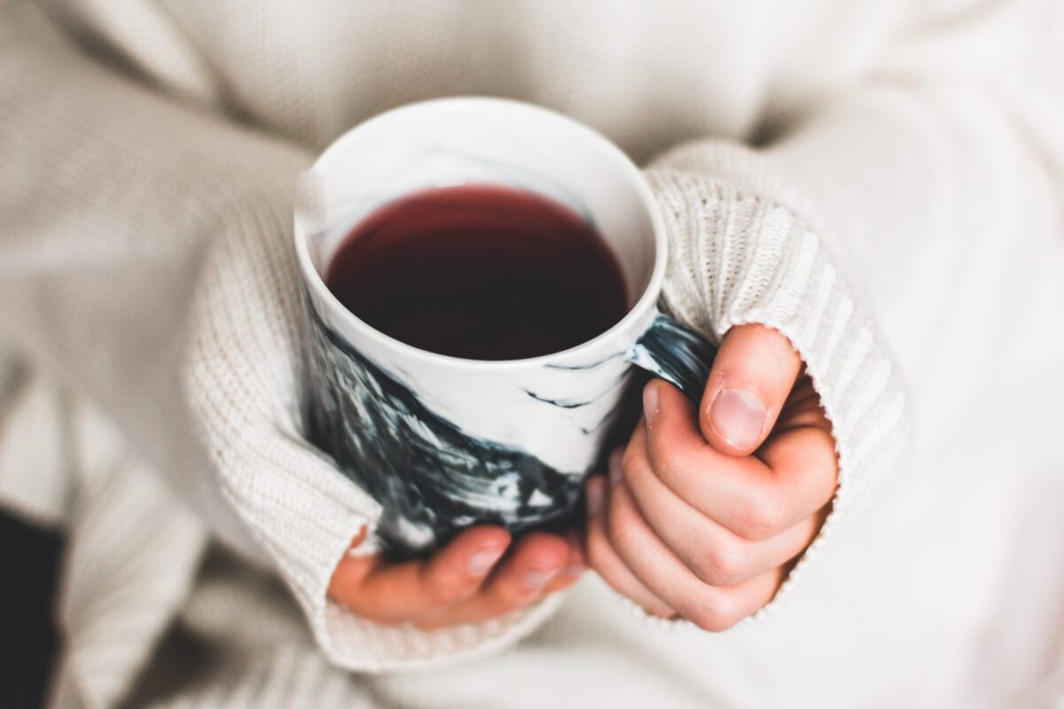 A person holding a cup of herbal tea