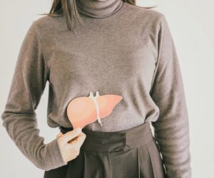 A person pointing to their liver to highlight health in January